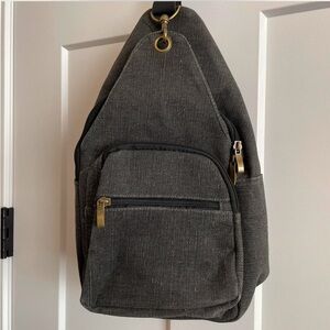 Grey canvas crossbody bag with adjustable straps and multiple pockets
